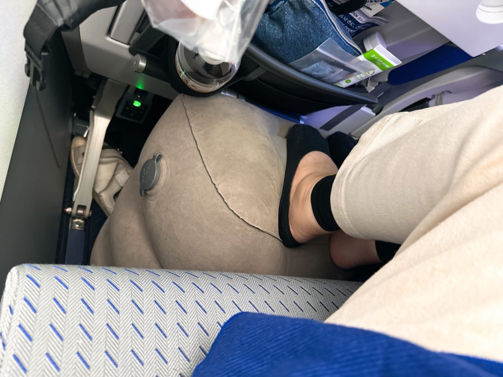 旅行用フットレスト使用中の写真。ANAフライングホヌ機内で足を置いた状態