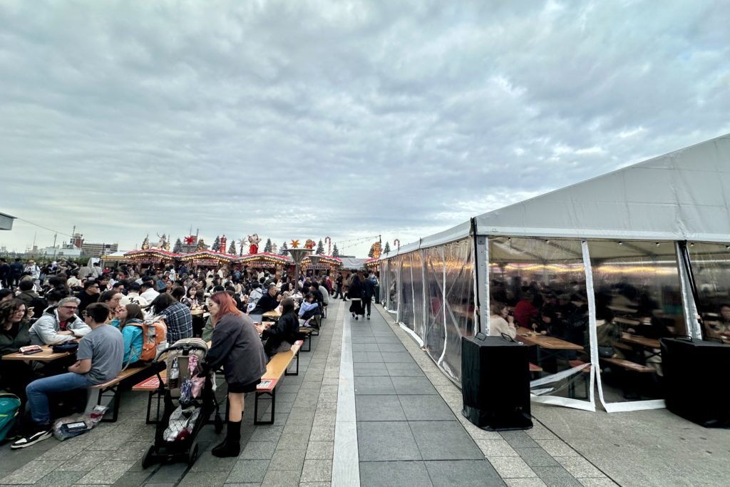 東京スカイツリーのクリスマスマーケット2025の様子。飲食の座席エリアは屋内と屋外で分かれている。